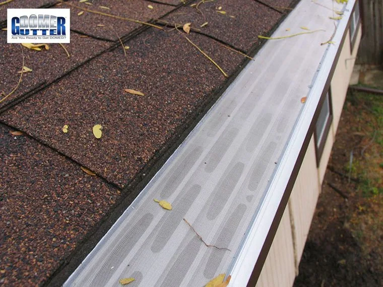 GutterDome GD45 gutter guard installed along a comp shingle roof and downspout.
