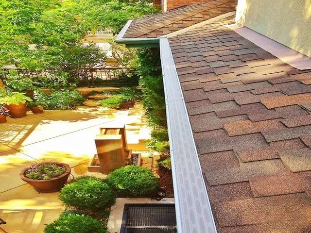 GutterDome GD45 gutter guard installed along a comp shingle roof above a patio.